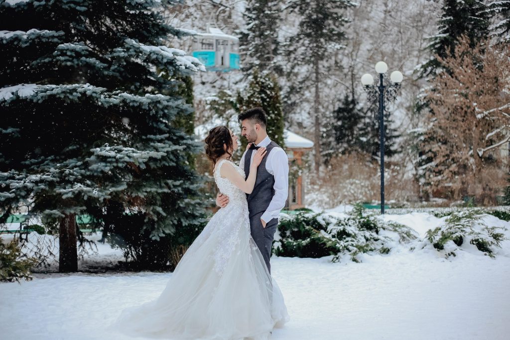 winter weddings - couple standing on snow. Best wedding trends this 2024