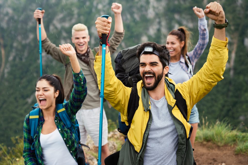 Group of young friends hiking in countryside. Multiracial happy people travelling in nature