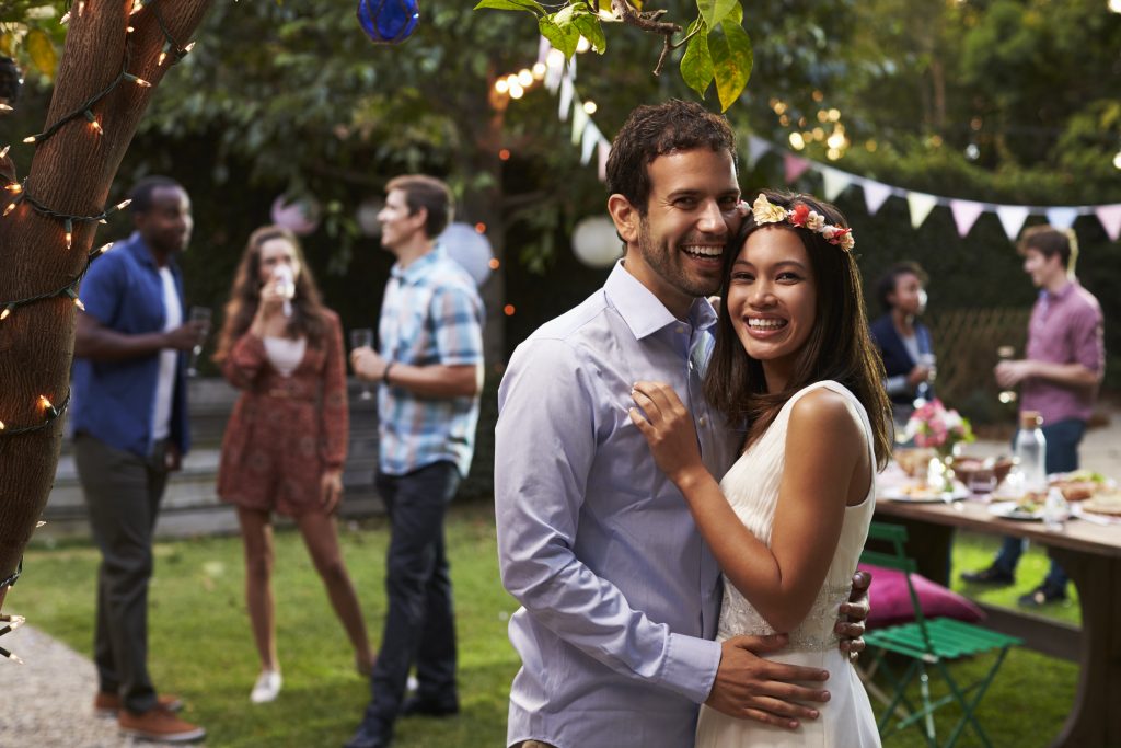 Portrait Of Couple Celebrating Wedding With Backyard Party