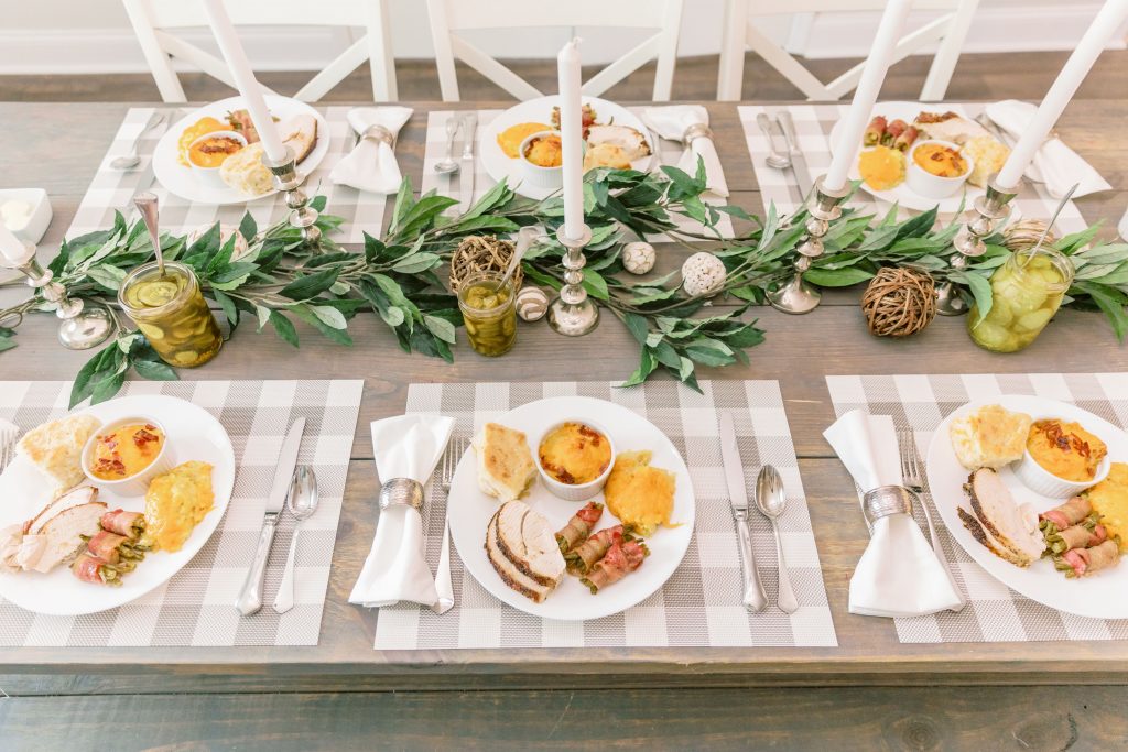 A top view of a wedding table with meals on white plates and beautiful, elegant decorations