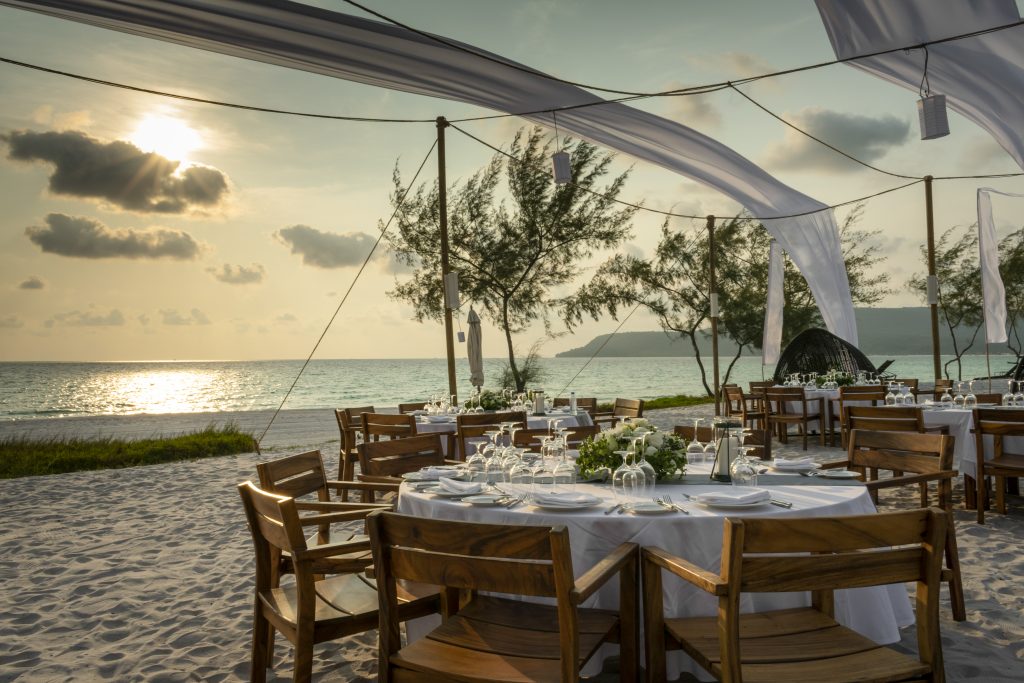 romantic wedding table design at sunset outside on tropical asian beach in bali indonesia
