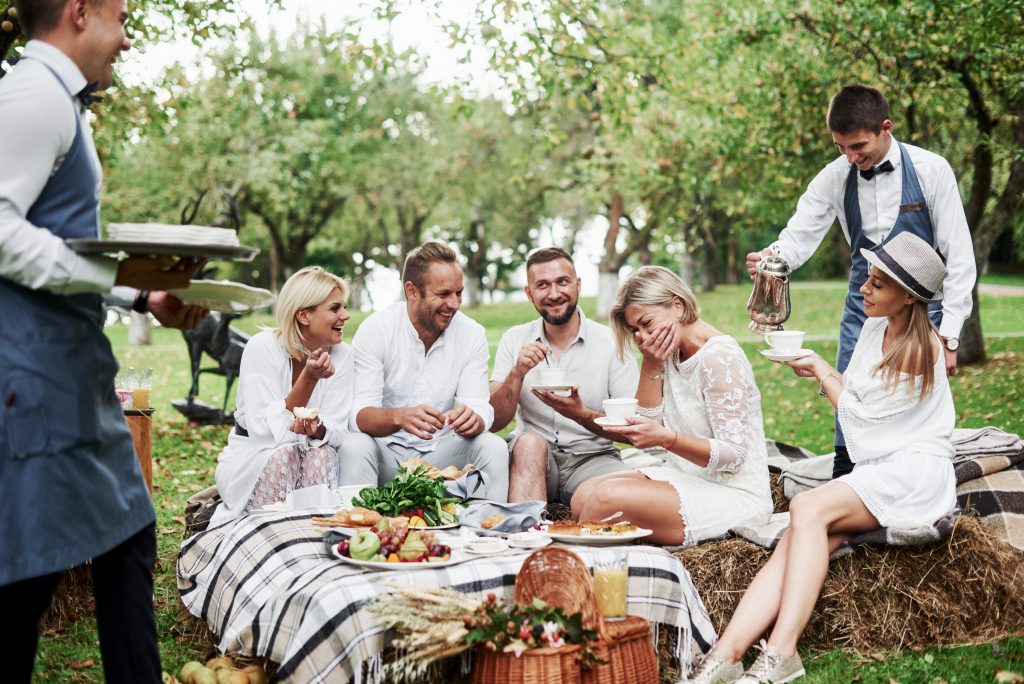 Worthy and fun service. Group of adult friends have a rest and conversation in the backyard of restaurant at dinner time.