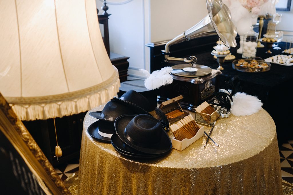 An old retro gramophone, hats and cigars are on the table.