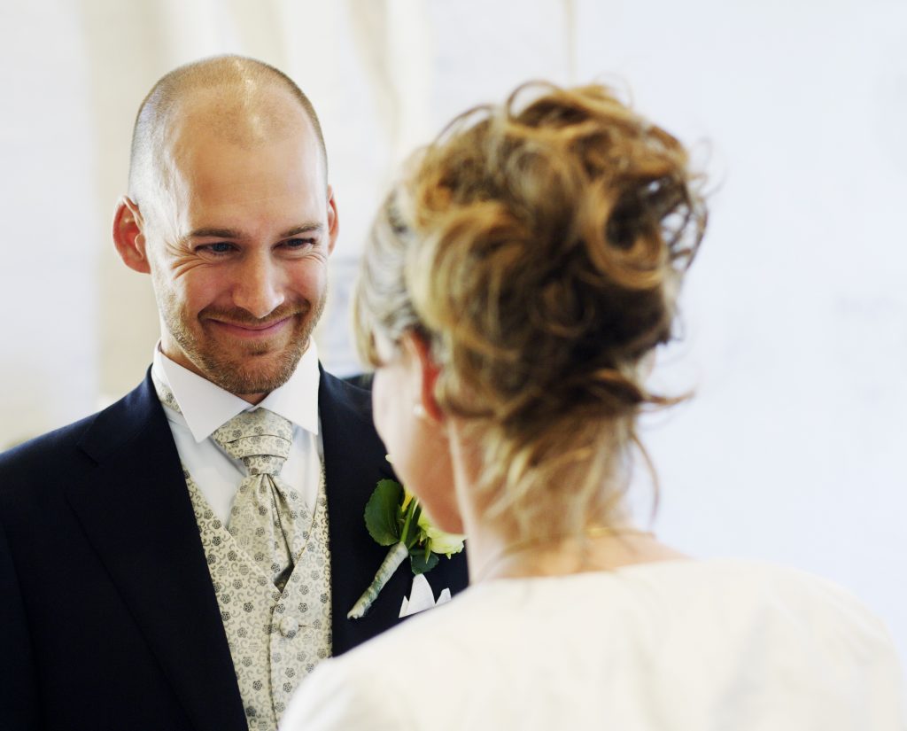 Smiling groom looking at bride during wedding