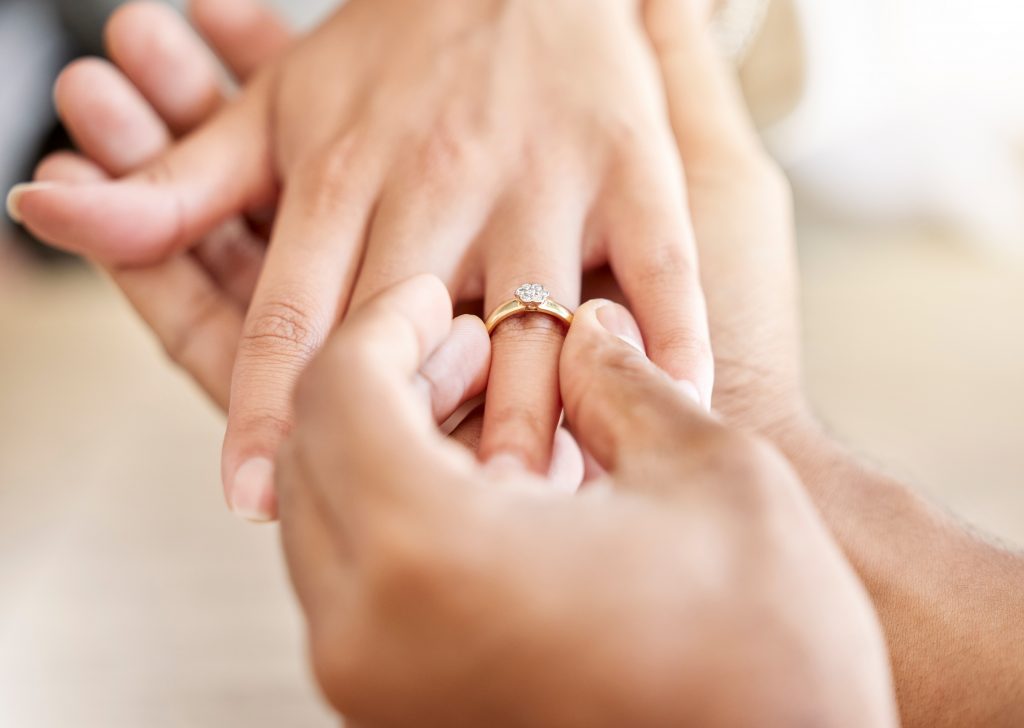 Closeup hand of proposal engagement ring after romantic, caring and loving man proposes to woman. B.