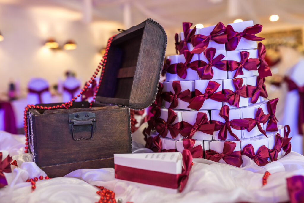 wooden chest on the table with a violet tablecloth and small gifts for guests from the newlyweds