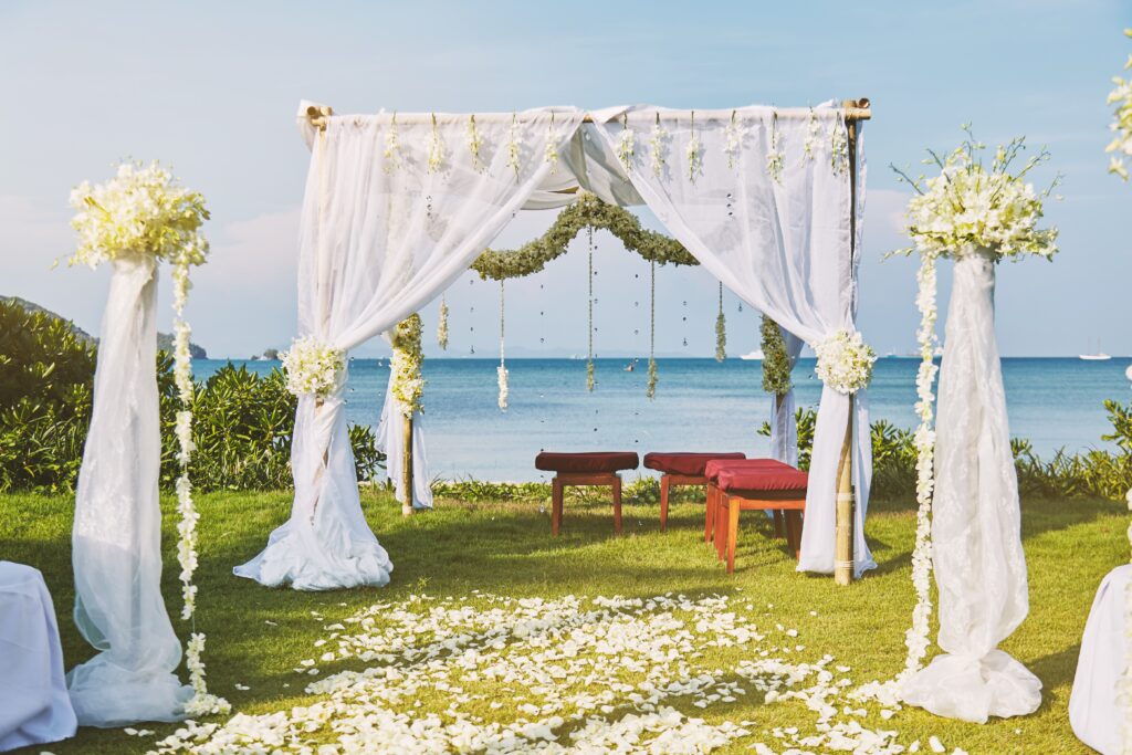 The beautiful wedding venue setting with flowers, floral decoration on arch with panoramic ocean view in background