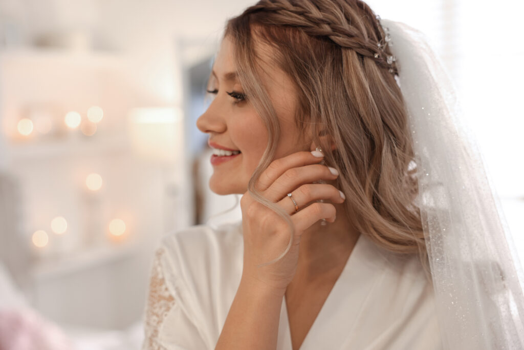 Happy bride with beautiful makeup and hairstyle at home. Wedding day