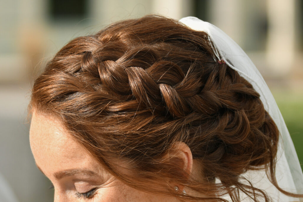Red hair of the bride braided at a wedding